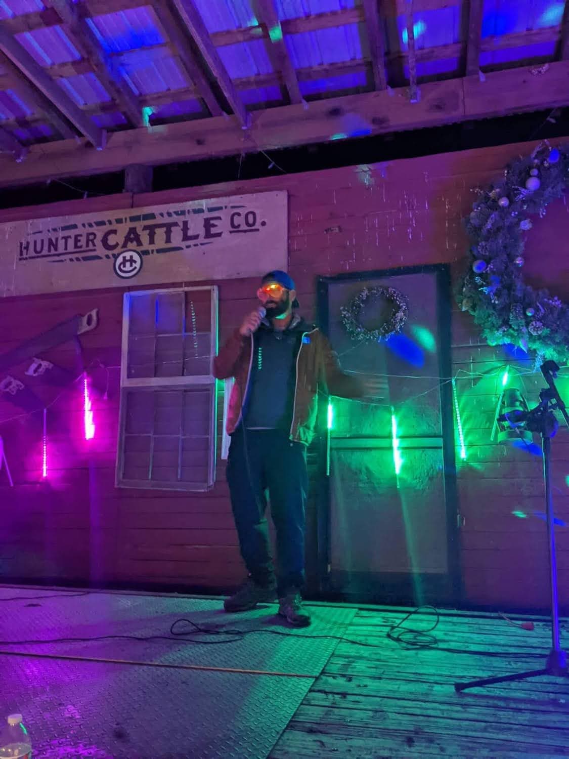 Performer on the lit night stage at Hunter Cattle Co
